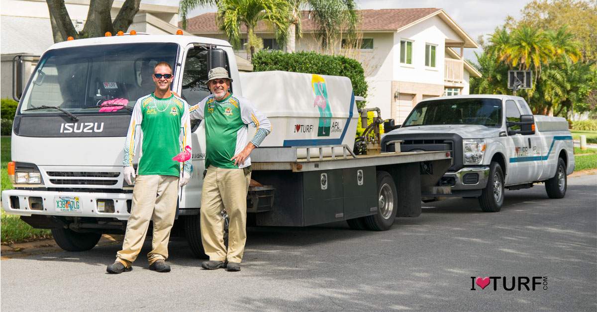 John and Rick standing next to the spray trucks